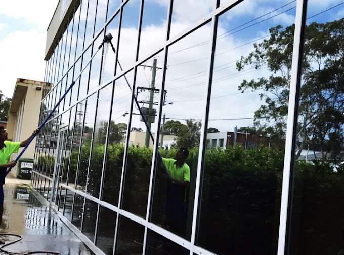 Professional window cleaners using eco-friendly methods and safe cleaning technique